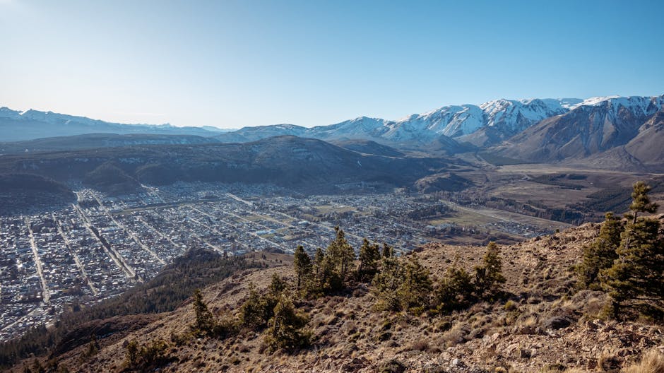A breathtaking panoramic view of Esquel, Argentina, with snow-capped mountains and clear blue skies